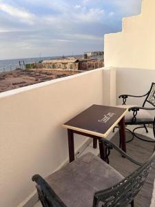a table and chairs on a balcony overlooking the ocean at camp caesar in Dahab