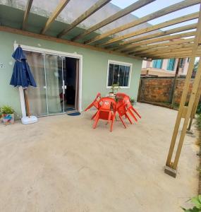 a patio with a table and an umbrella at Casa temporada perto do centro in Garopaba