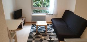 a living room with a couch and a table at Studio meublé centre ville Paray A4 in Paray-le-Monial