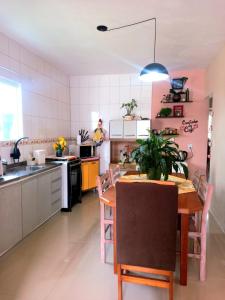 a kitchen with a table and a dining room at Casa temporada perto do centro in Garopaba