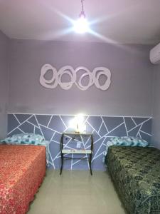 a room with two beds and a table with two plates on the wall at Casa temporada perto do centro in Garopaba