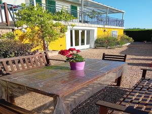 une table en bois avec un pot de fleurs dessus dans l'établissement Vacation Home in France with Pool, à Chaumard