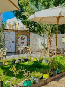 a patio with a table and chairs and an umbrella at camp caesar in Dahab