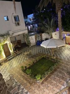 a patio with an umbrella and a table and chairs at camp caesar in Dahab