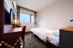 a hotel room with a bed and a desk and a window at スペースポートホテル大分 -Spaceport Hotel Oita- in Kunisaki +57 photos
