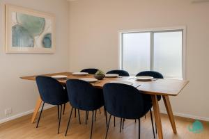 a dining room with a wooden table and blue chairs at Casa Bella in Lakeside +8 photos