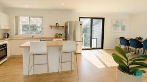a kitchen with a counter and chairs and a refrigerator at Casa Bella in Lakeside