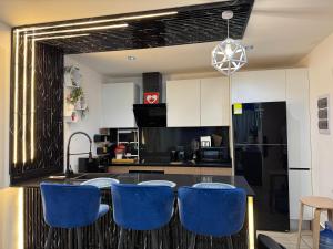 a kitchen with black and white cabinets and blue chairs at Downtown Punta Cana-Welcome to our Love Nest! in Punta Cana +31 photos