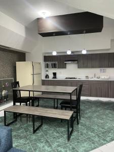 een keuken met een tafel, stoelen en een koelkast bij Departamentos Arista in Oaxaca City