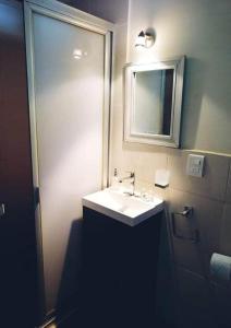 een badkamer met een witte wastafel en een spiegel bij Departamentos Arista in Oaxaca City +13 foto's