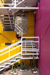 een trappenhuis in een gebouw met gele en roze muren bij Departamentos Arista in Oaxaca City