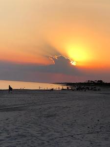 a sunset on a beach with people on the beach at El Romance in Jaureguiberry +5 photos
