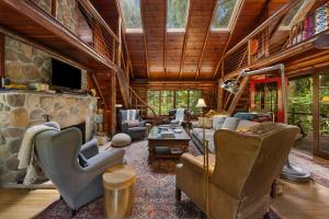 a living room with a stone fireplace and chairs at Lookout Log Cabin in Rhododendron