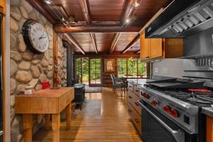 a kitchen with a stove and a clock on the wall at Lookout Log Cabin in Rhododendron