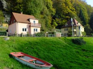 ein Boot, das auf dem Gras vor einem Haus sitzt in der Unterkunft Ferienhaus Strandhaus in Bad Schandau