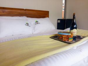 Cama con bandeja de comida y botella de vino en Cabaña Colibrí Silvania Cundinamarca, en Silvania