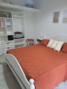 een slaapkamer met een bed met een oranje dekbed bij Casa de Andres in Ataliva Roca