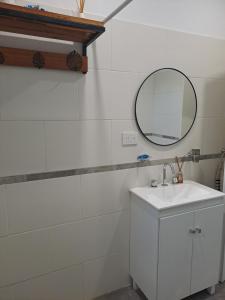 een badkamer met een witte wastafel en een spiegel bij Casa de Andres in Ataliva Roca