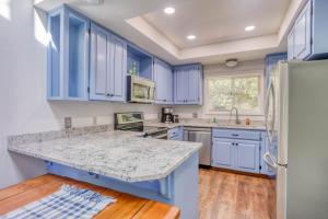 a kitchen with blue cabinets and a marble counter top at Waldport Serenity in Waldport