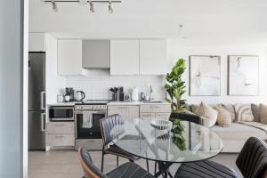 a kitchen and living room with a glass table at Toronto Skyline Stay Modern Design & View in Toronto