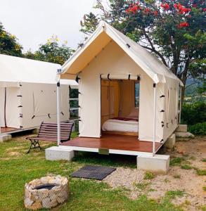 a small white tent with a bed in it at Cabaña tipi Ardilla Silvania Cundinamarca in Silvania