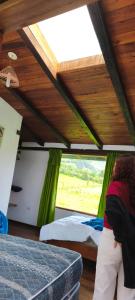 una persona parada en una habitación con una cama y una ventana en Lodge Chagras y Arrieros, 