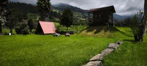 Un campo de hierba con una pequeña casa encima. en Lodge Chagras y Arrieros, 