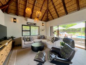 a living room with a couch and a table at Wildlife Estate Villa - Pool - Boma - Bushlife in Hoedspruit