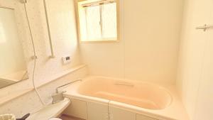 a bath tub in a bathroom with a window at らくがきシーサイド牛窓 in Setouchi +40 photos