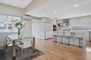 a kitchen with a glass table and white cabinets at LUXURY PET-FRIENDLY's BENDIGO ACCOMMODATION 4 BEDROOM 2 BATHROOMS ENTIRE HOME WALK TO BENDIGO CBD LAKE EASTER FESTIVAL Bendigo Regional Tennis Centre BRTC Central Deborah Gold Mine Bendigo Art Gallery Golden Dragon Museum Rosalind Park The Great Stupa in Bendigo
