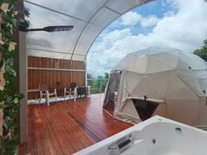 an open patio with a tub on a deck at Glamping Morpho Azul Silvania Cundinamarca in Silvania