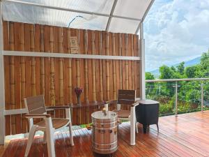 a patio with a table and chairs on a deck at Glamping Morpho Azul Silvania Cundinamarca in Silvania
