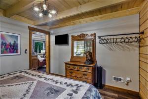 a bedroom with a bed and a dresser and a mirror at Riverfront, Authentic, Luxury Log Cabin-Black Bear in Wasilla