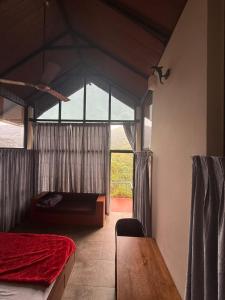 a bedroom with a bed and a large window at Kood Heritage cottages in Vagamon