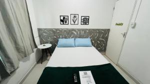 Quero mais arraial suites في أرايال دو كابو: غرفة صغيرة بها سرير وطاولة