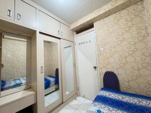 雅加达Cozy 2BR Kalibata City的一间带床和镜子的小卧室