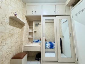 雅加达Cozy 2BR Kalibata City的步入式衣柜,配有白色橱柜和镜子