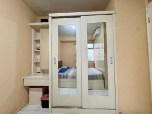 雅加达Cozy 2BR Kalibata City的一间设有衣柜的房间,里面配有一张床