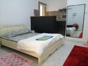 a bedroom with a bed and a large mirror at Résidence hibis chez M&B in Saly Portudal