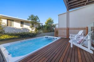 15 Scrub Rd - A Modern Coastal Luxury Retreat في كولوم بيتش: حوض سباحة على سطح السفينة مع كرسي وكرسي