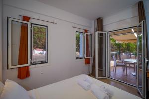 a room with a bed and a balcony with a table at Romanos Beach Villas in Romanu