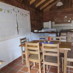 Una cocina con una mesa y sillas de madera. en Cabañas Agua de Piedra, en Villa Giardino 2 fotos más