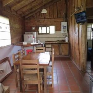 Una cocina con una mesa y sillas en una habitación. en Cabañas Agua de Piedra, en Villa Giardino