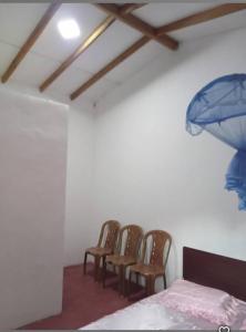 a group of chairs in a room with a bed at Uva Guest Udawewa in Diyatalawa