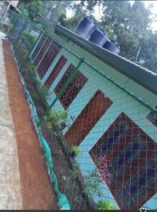 a fence with a mosaic mural on the side of a building at Uva Guest Udawewa in Diyatalawa