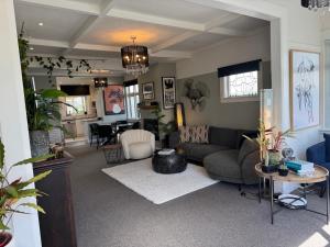 a living room with a couch and a table at Unique Beachside Home in Eastbourne in Lower Hutt
