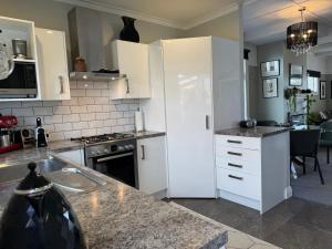 a kitchen with white cabinets and a counter top at Unique Beachside Home in Eastbourne in Lower Hutt +18 photos