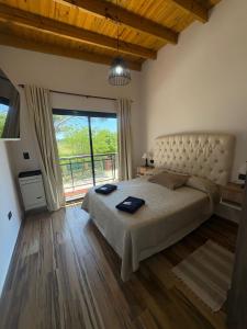 Cabaña La Arianna في سانتا تيريسيتا: غرفة نوم بسرير كبير ونافذة كبيرة