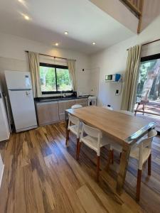 Cabaña La Arianna في سانتا تيريسيتا: مطبخ مع طاولة خشبية وثلاجة