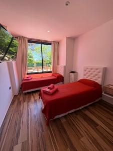 Cabaña La Arianna في سانتا تيريسيتا: غرفة نوم بها سريرين ونافذة كبيرة +5 صور